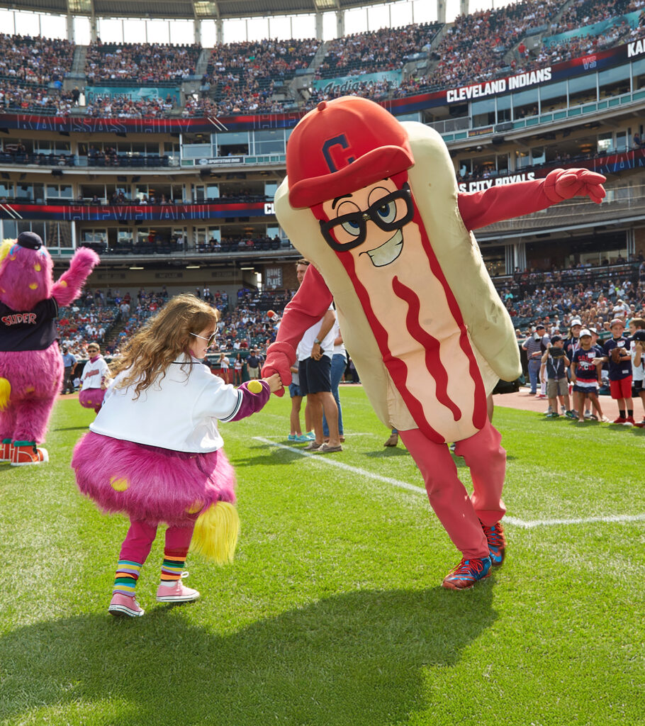 Cleveland Hog Dog Mascot high fiving a kid.
