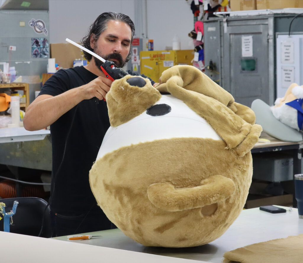 Olympus mascot maker hand making a custom foam bear head.