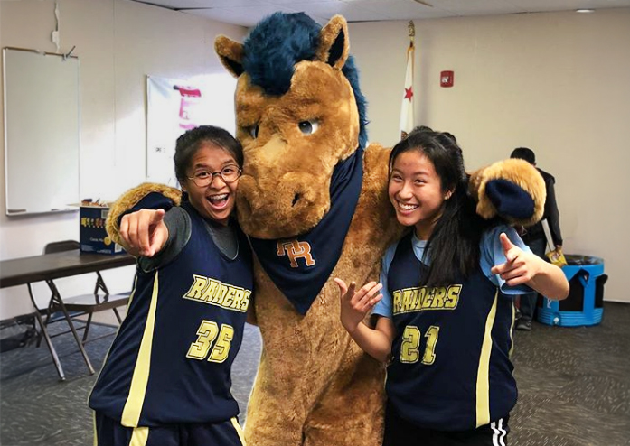 Storm Horse Mascot for Rowland High School Mascot posing for a photo with students.