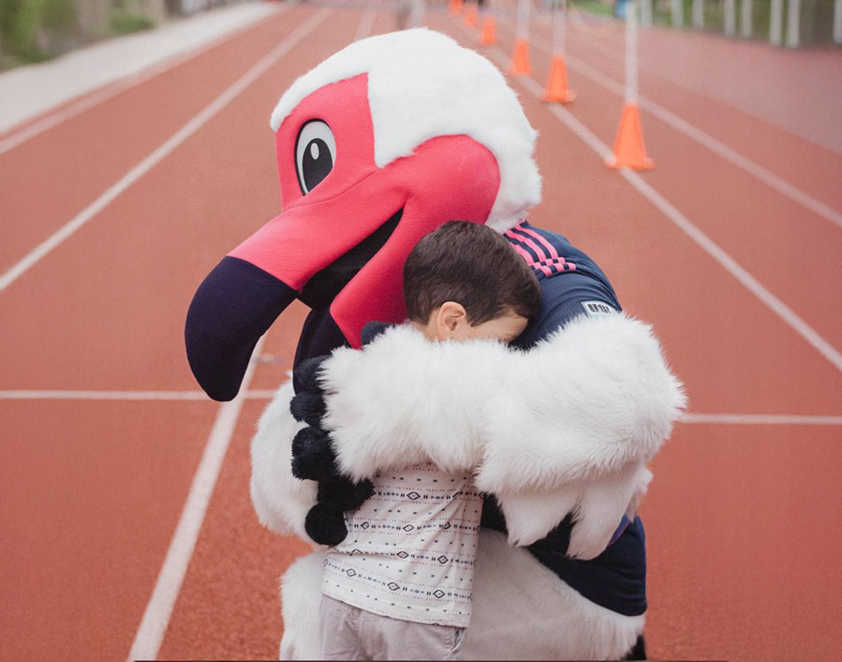 Tormenta FC Bird Mascot hugging kid
