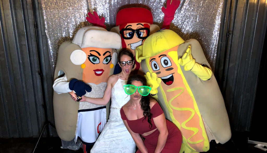 The Cleveland Guardians Racing Mascots posing with two fans at a wedding.