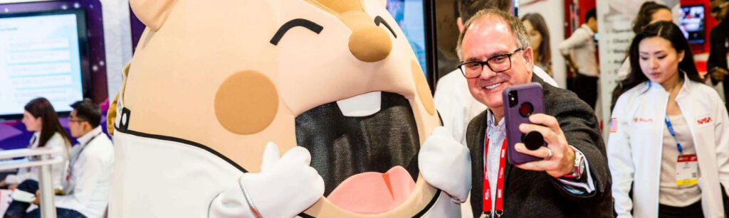 Mascot At Tradeshow Taking Selfie With Man