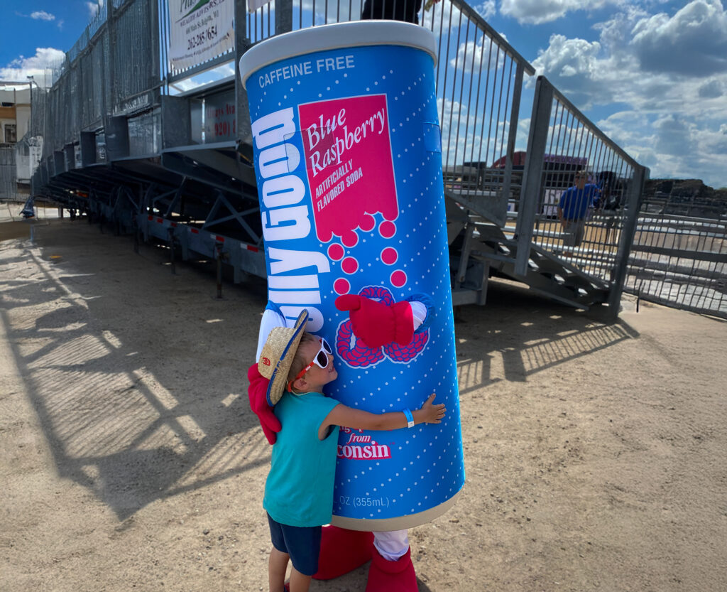 Kid hugging Jolly Good Mascot