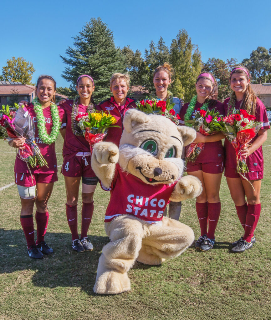 Willie the Wildcat Mascot for Chico State posing with the girls soccer team.