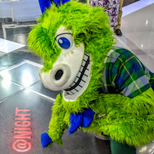 Dark blurred background photo of two goat mascots with kids