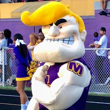Dark blurred background photo of a muscley man school mascot
