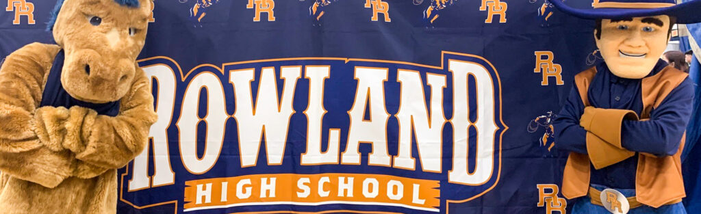 Rowland High School Mascots posing by school banner