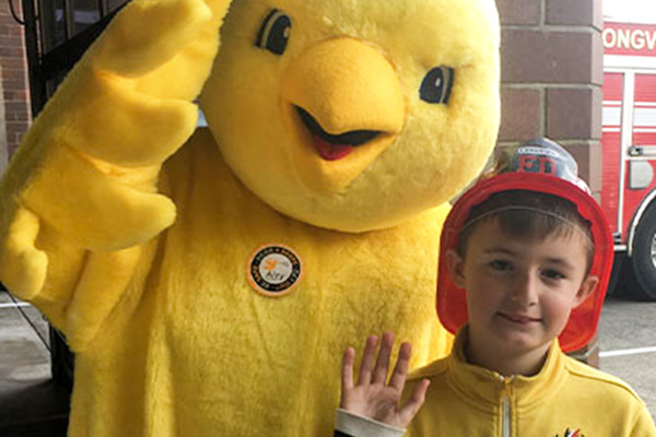 Airy the Canary waving with a child