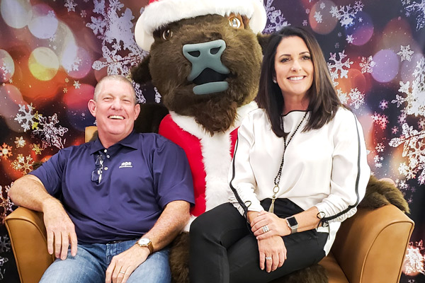 Roman the Buffalo Mascot with employees on his lap