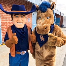 Cowboy and horse mascot pose together