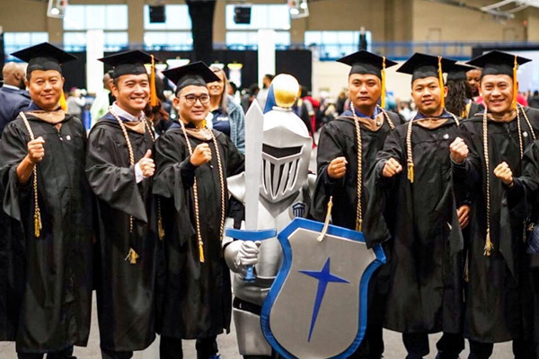 Sir Maximous posing with graduates