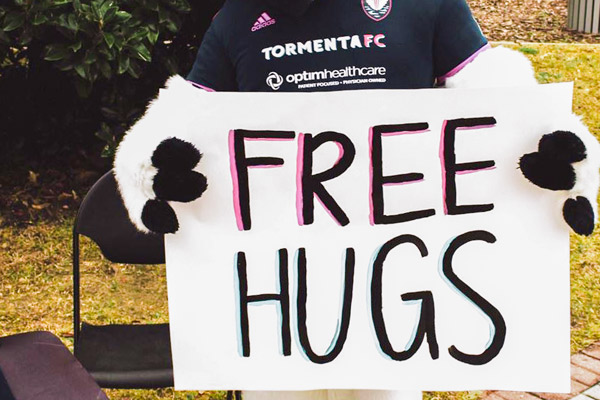 Tormenta FC Bolt the Ibis Mascot holding "free hugs sign"