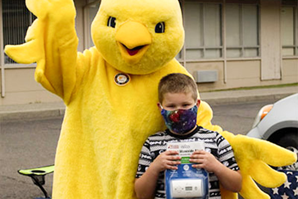 Airy the Canary with a child holding a CO detector