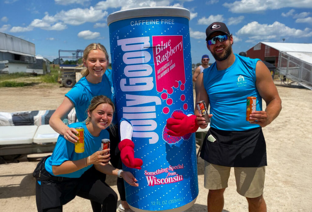 Three customers posing with Jolly Good Mascot