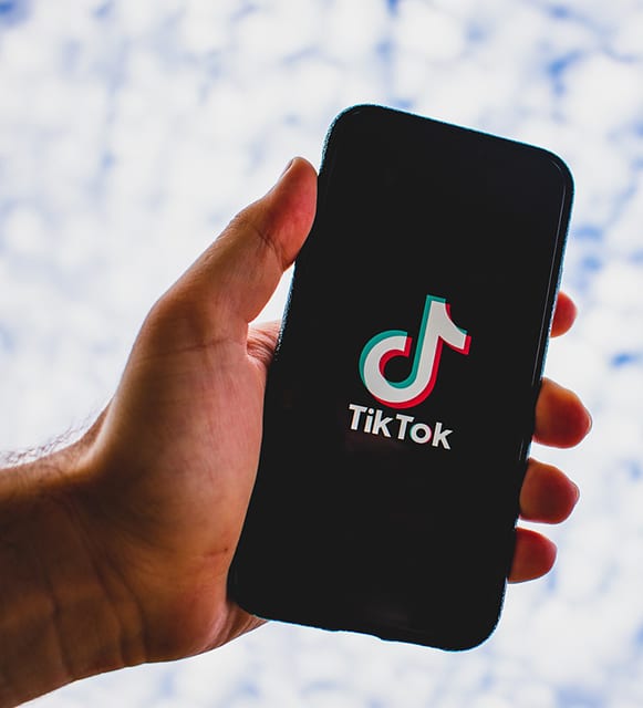 Hand Holding Phone With TikTok Logo