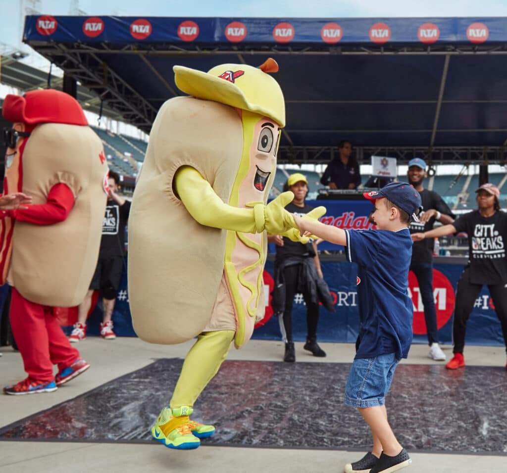 Cleveland Hotdog Mascot dancing with kid.