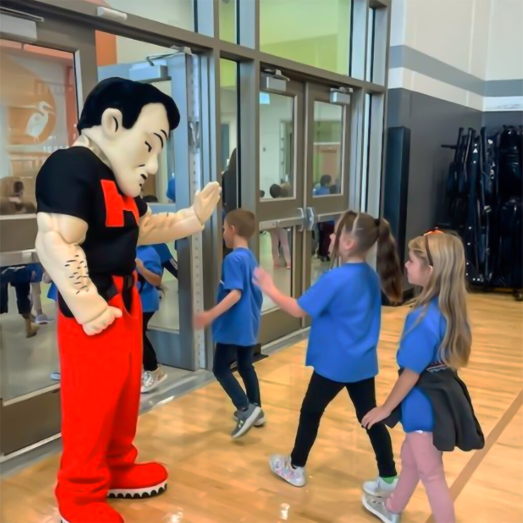 Horicon Marshman Mascot giving high fives to students