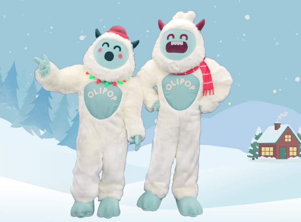 Mascots Oli and Pop from OLIPOP posing in a winter wonderland setting.
