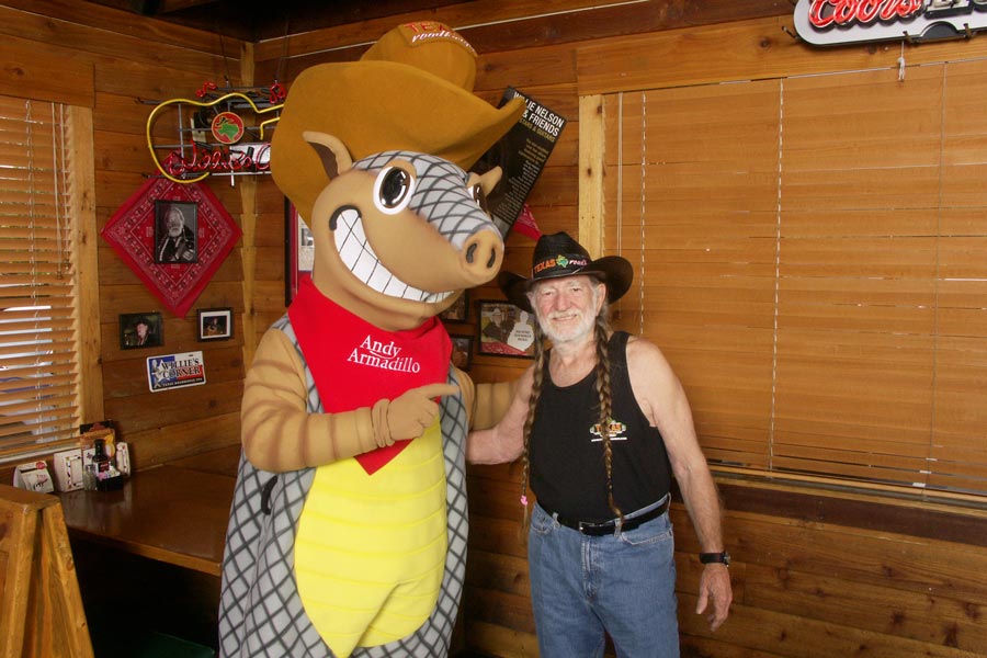 Andy Armadillo posing for a picture with Willie Nelson.