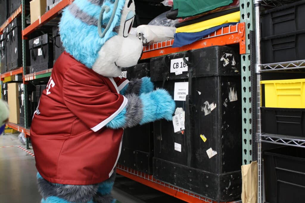 Ollie Olympus examining a mascot case in our warehouse.
