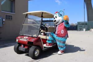 Ollie Olympus striking a pose on a golf cart near Summerfest grounds.